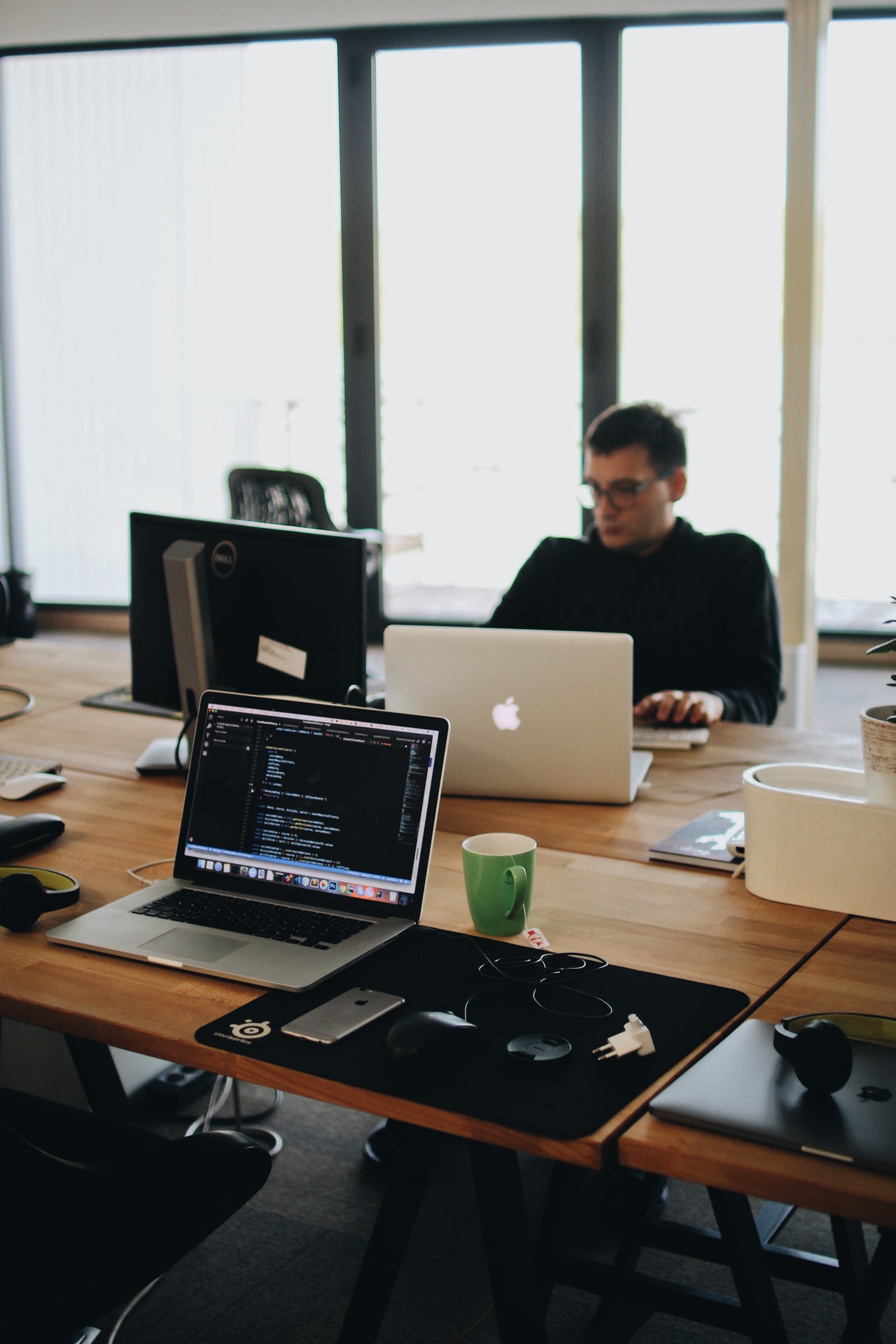 Web Developer and Web Designer programming on laptop in office